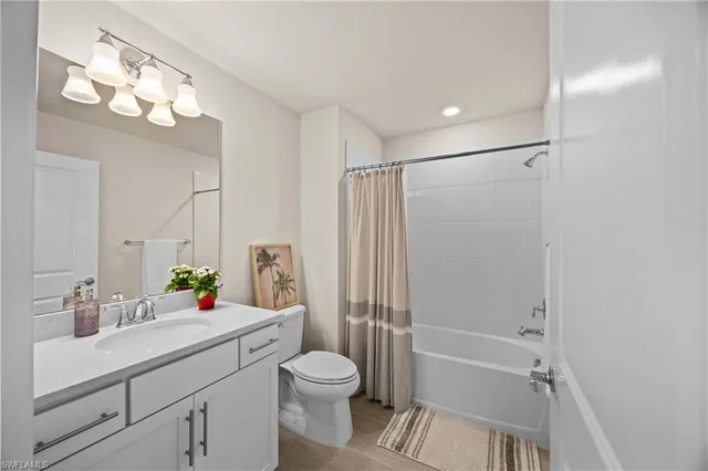 a bathroom with a sink a toilet a mirror and shower