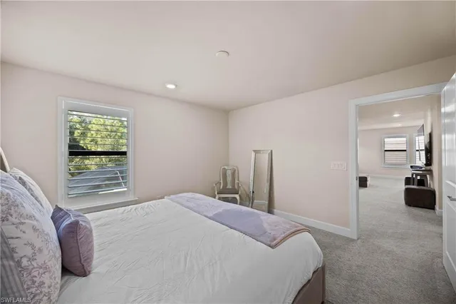 a bedroom with a bed and a large window