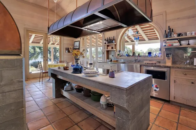 a kitchen with stainless steel appliances granite countertop a sink a stove and a wooden floors