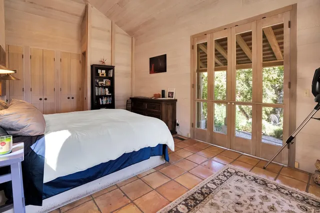 a bed sitting in a bedroom next to a window