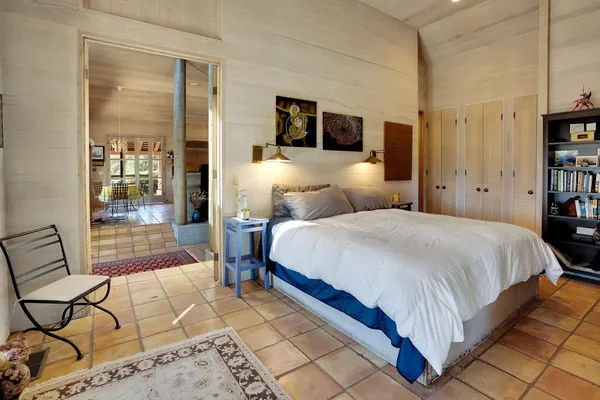 a bedroom with a bed and glass door