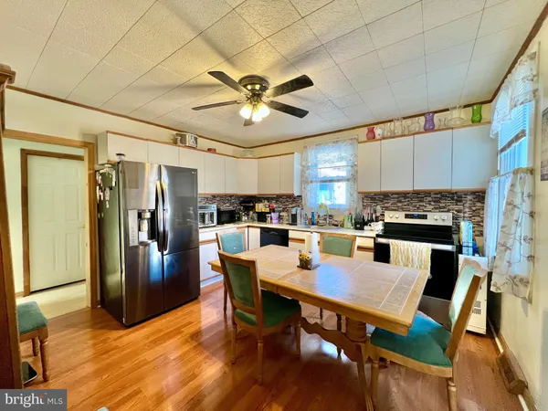 a view of a dining room with furniture a kitchen and chandelier