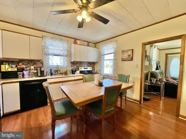 a room with stainless steel appliances granite countertop table chairs and a refrigerator