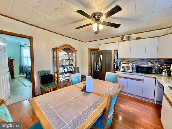 a kitchen with stainless steel appliances kitchen island granite countertop a dining table chairs and a refrigerator