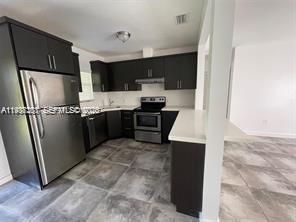 6441 Southwest 30th Street Miami, FL 33155 - Photo 5 of 13 a kitchen with stainless steel appliances a refrigerator and a sink