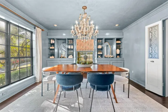 a dining room with furniture a chandelier and wooden floor