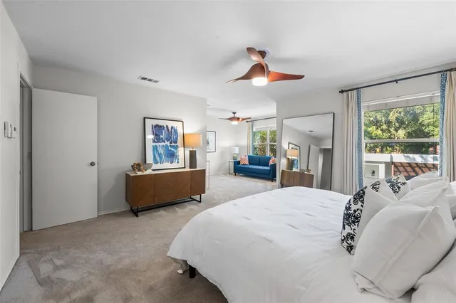 a bedroom with a bed a couch and large window