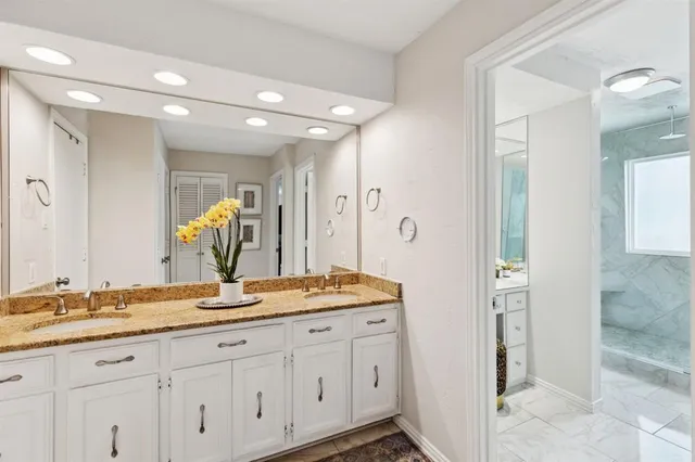 a bathroom with a granite countertop sink and a mirror