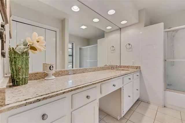 a bathroom with a granite countertop double vanity sink and a mirror
