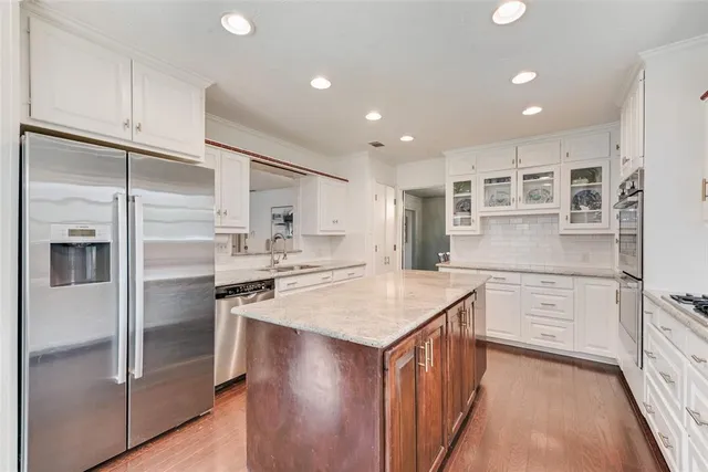 a kitchen with kitchen island white cabinets and refrigerator