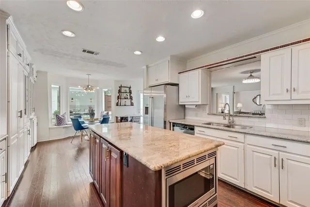 a open kitchen with stainless steel appliances granite countertop a lot of counter space and wooden floors