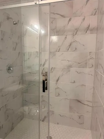 a bathroom with a granite countertop sink toilet a mirror and shower