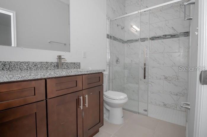 9451 North Emellia Avenue Citrus Springs, FL 34433 - Photo 12 of 24 a bathroom with a granite countertop sink toilet a mirror and shower