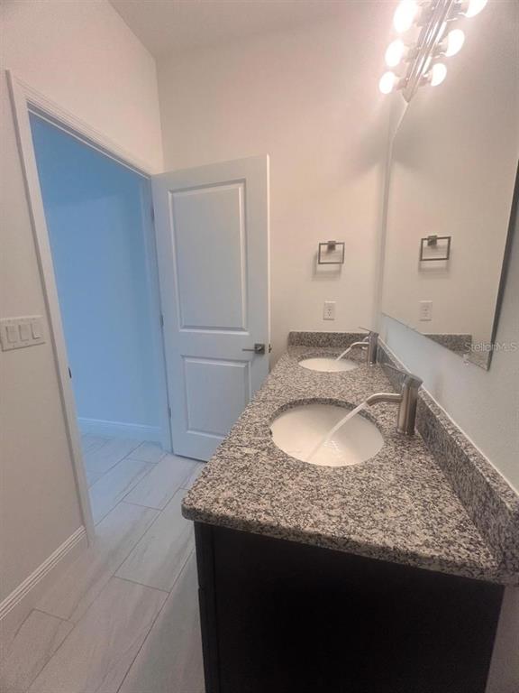 9451 North Emellia Avenue Citrus Springs, FL 34433 - Photo 14 of 24 a bathroom with a granite countertop sink and a mirror