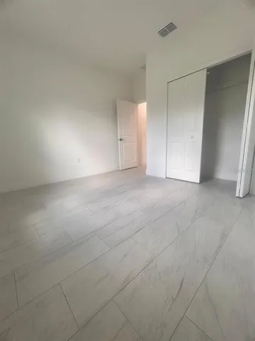 a bathroom with a granite countertop sink a toilet a mirror a bathtub and shower