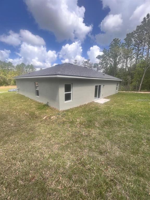9451 North Emellia Avenue Citrus Springs, FL 34433 - Photo 22 of 24 a backyard of a house with table and chairs