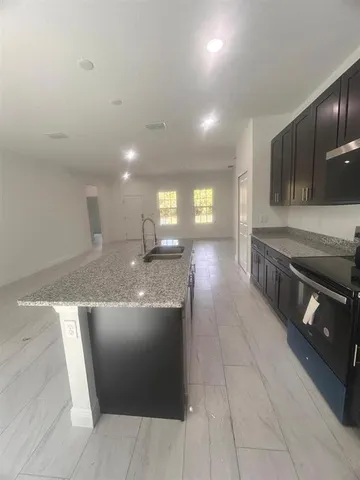 a kitchen with stainless steel appliances granite countertop a sink and a stove