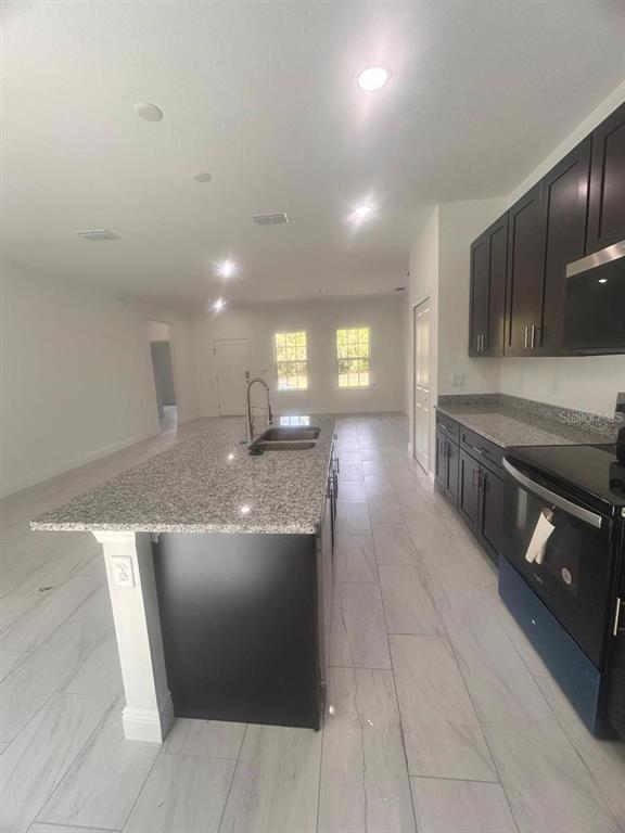 9451 North Emellia Avenue Citrus Springs, FL 34433 - Photo 9 of 24 a kitchen with stainless steel appliances granite countertop a sink and a stove