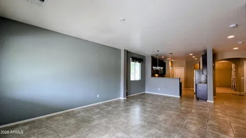 an empty room with wooden floor and fan