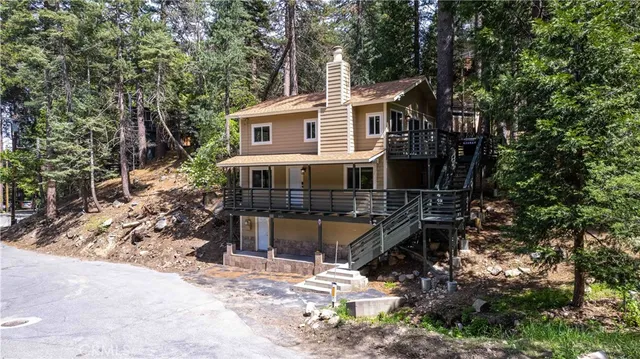 a front view of house with yard and trees in the background
