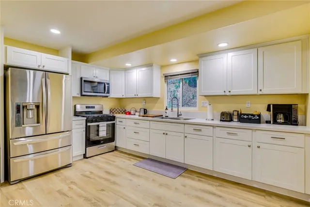 a kitchen with granite countertop a refrigerator stove and sink