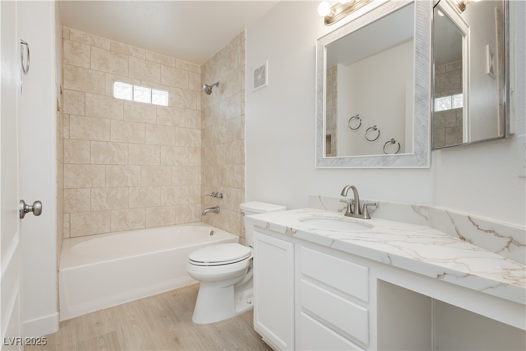 7400 West Flamingo Road, Unit 2033 Las Vegas, NV 89147 - Photo 5 of 38 Guest bathroom with updated tile surround, quartz counter tops, new mirror, toilet, sink and faucet.
