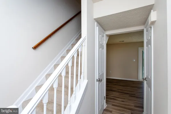 a view of a hallway with wooden floor and staircase