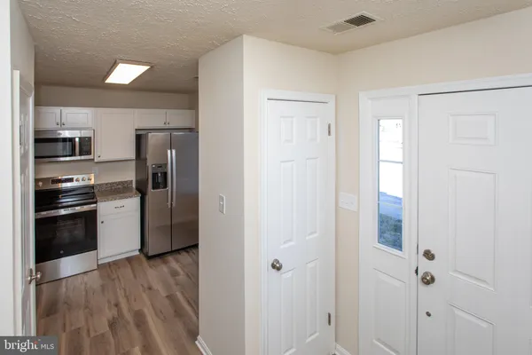 a kitchen with a refrigerator and a stove top oven