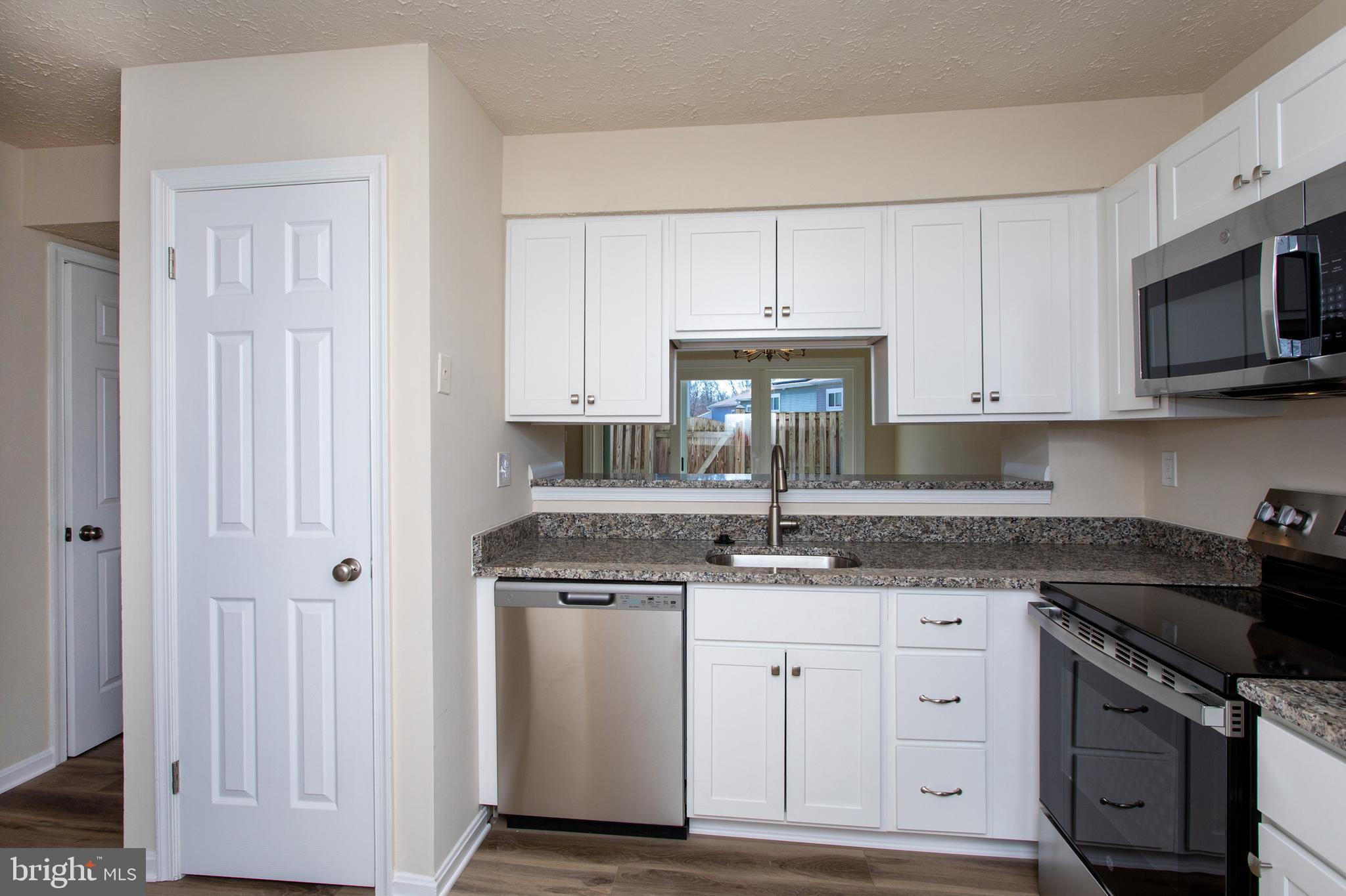3147 Heath Cote Road Waldorf, MD 20602 - Photo 5 of 33 a kitchen with stainless steel appliances granite countertop a sink stove and microwave