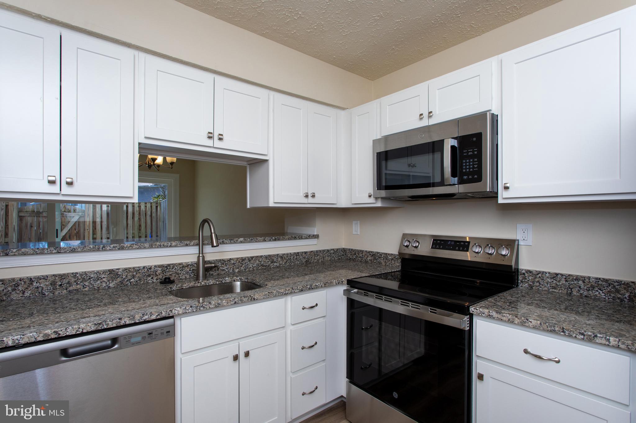 3147 Heath Cote Road Waldorf, MD 20602 - Photo 7 of 33 a kitchen with stainless steel appliances granite countertop white cabinets granite counter tops and a stove
