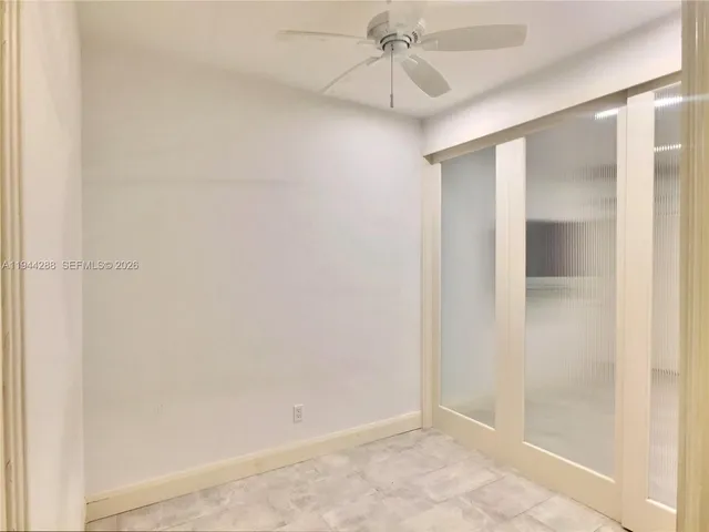 an empty room with a glass door and shower