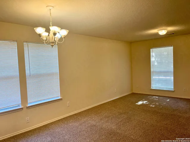 a view of a chandelier fan and refrigerator