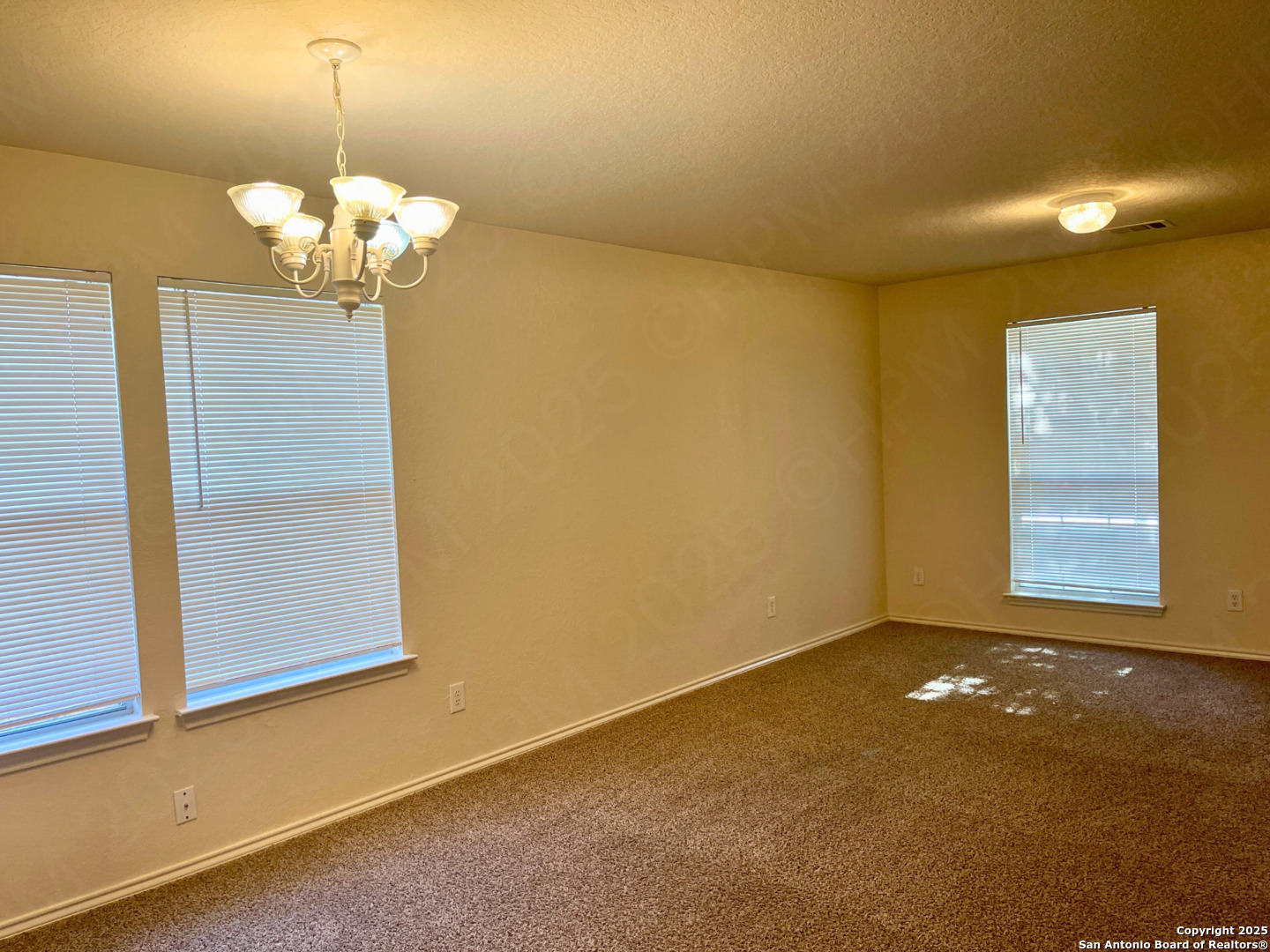 11027 Chicory Field Helotes, TX 78023 - Photo 7 of 22 a view of a chandelier fan and refrigerator