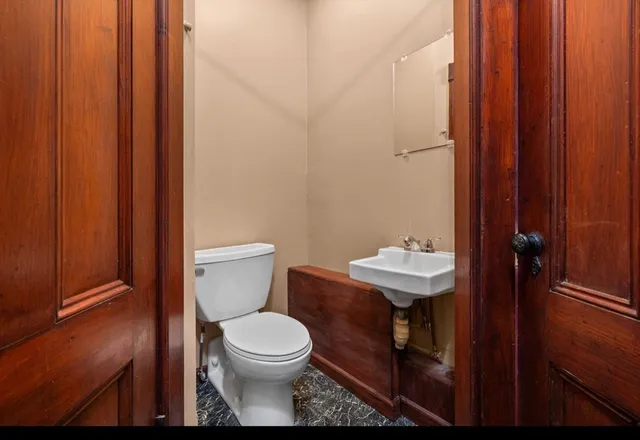 a bathroom with a toilet a sink and a mirror