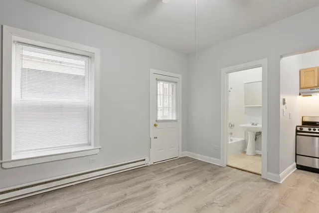 an empty room with a bathroom and a window