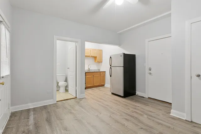 a view of kitchen with refrigerator and wooden floor