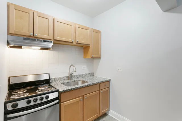 a kitchen with stainless steel appliances a sink a stove and cabinets