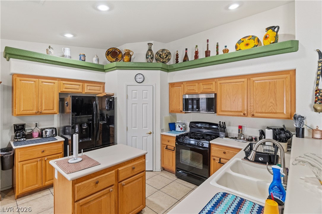 2516 Morrow Ridge Place Laughlin, NV 89029 - Photo 17 of 93 Kitchen featuring black appliances, a center island, light countertops, light tile patterned floors, and recessed lighting