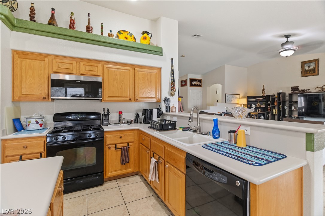 2516 Morrow Ridge Place Laughlin, NV 89029 - Photo 19 of 93 Kitchen with black appliances, light countertops, a peninsula, ceiling fan, and light tile patterned flooring