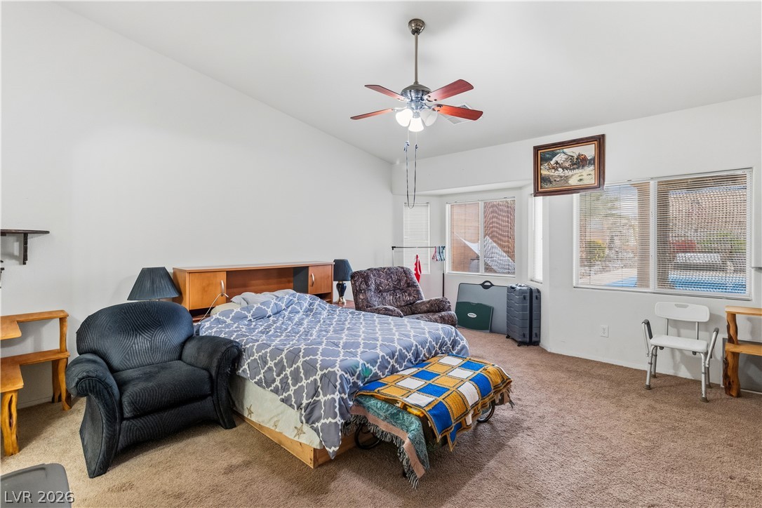 2516 Morrow Ridge Place Laughlin, NV 89029 - Photo 24 of 93 Primary Bedroom with light colored carpet, vaulted ceiling, and a ceiling fan