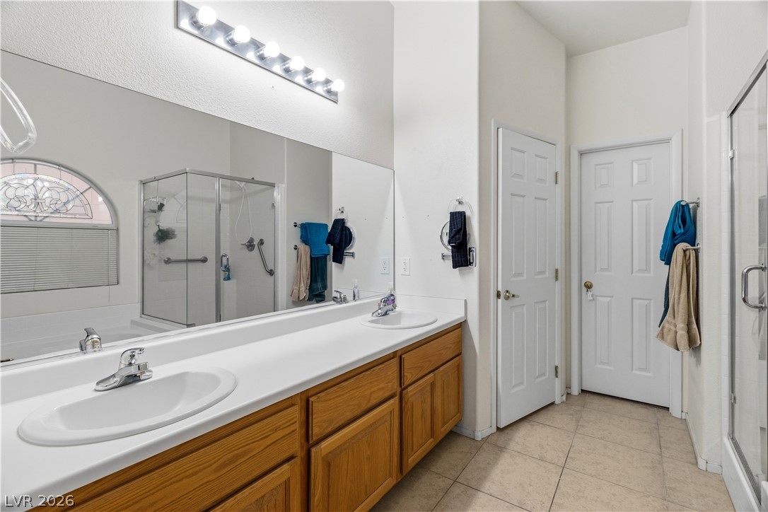 2516 Morrow Ridge Place Laughlin, NV 89029 - Photo 27 of 93 Primary Ensuite Bathroom with double vanity, a shower stall, light tile patterned floors, and a garden tub