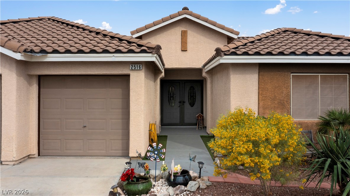 2516 Morrow Ridge Place Laughlin, NV 89029 - Photo 4 of 93 View of front of home with an attached garage, stucco siding, a tile roof, and concrete driveway