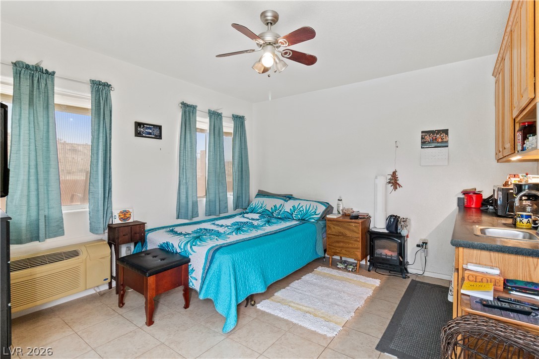 2516 Morrow Ridge Place Laughlin, NV 89029 - Photo 41 of 93 Casita / Guest Quarters Bedroom featuring ceiling fan, a wood stove, and light tile patterned floors