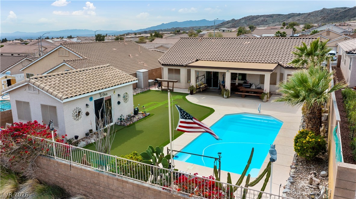 2516 Morrow Ridge Place Laughlin, NV 89029 - Photo 72 of 93 Back of property with a fenced backyard, stucco siding, a patio area, a mountain view, and a residential view