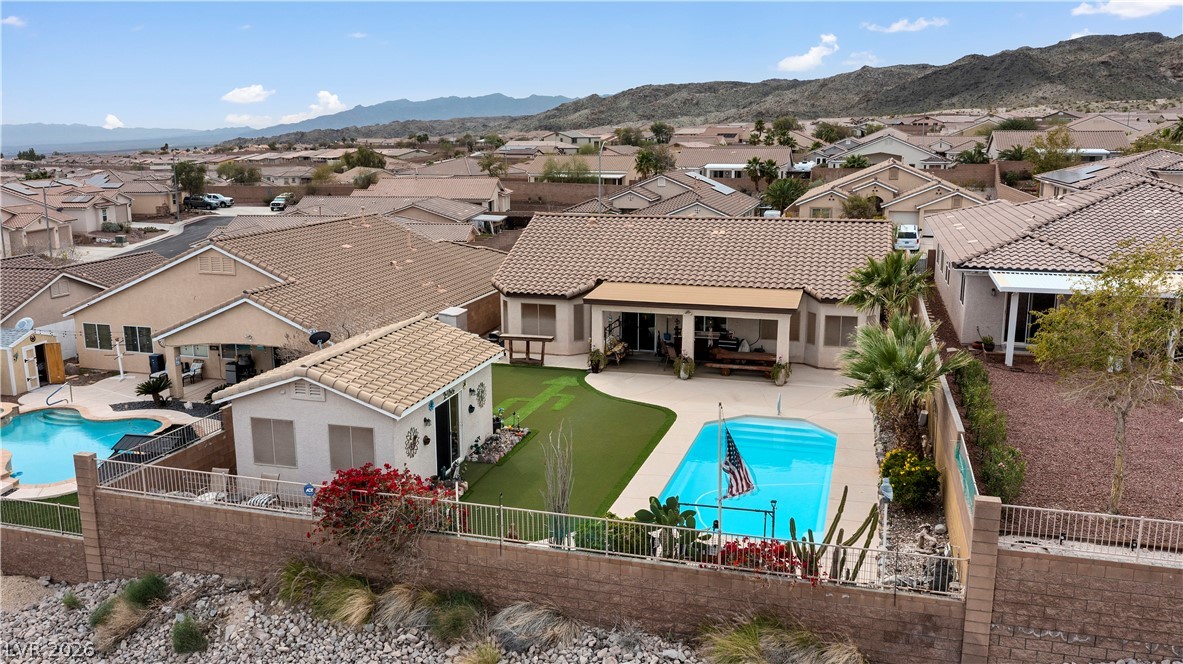2516 Morrow Ridge Place Laughlin, NV 89029 - Photo 82 of 93 Back of property featuring a fenced backyard, stucco siding, a residential view, a patio area, and a tiled roof