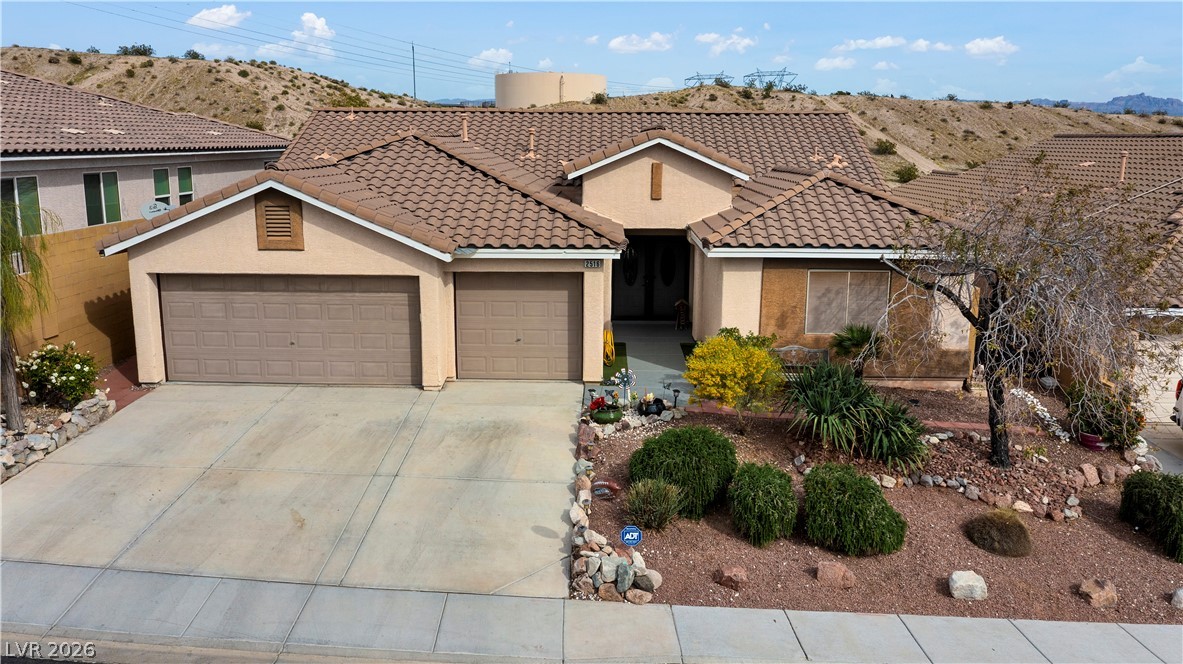 2516 Morrow Ridge Place Laughlin, NV 89029 - Photo 91 of 93 View of front of home with a garage, stucco siding, concrete driveway, and a tiled roof