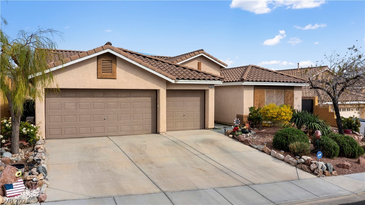 2516 Morrow Ridge Place Laughlin, NV 89029 - Photo 92 of 93 View of front of house featuring stucco siding, a tiled roof, a garage, and driveway