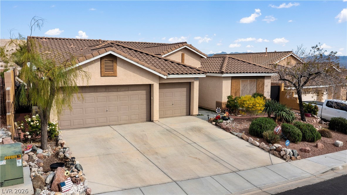 2516 Morrow Ridge Place Laughlin, NV 89029 - Photo 93 of 93 View of front of house with stucco siding, a tiled roof, an attached garage, and driveway