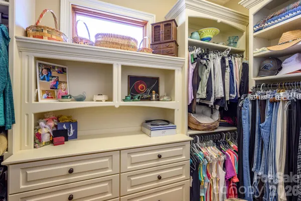 a view of walk in closet with clothes and shoes