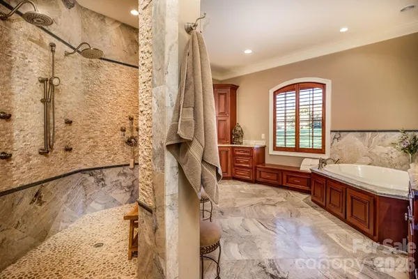 a spacious bathroom with a tub sink and mirror